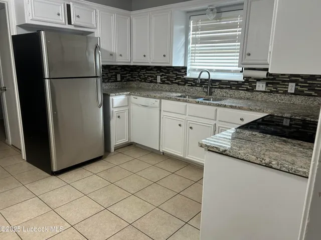 a kitchen with a refrigerator sink and cabinets