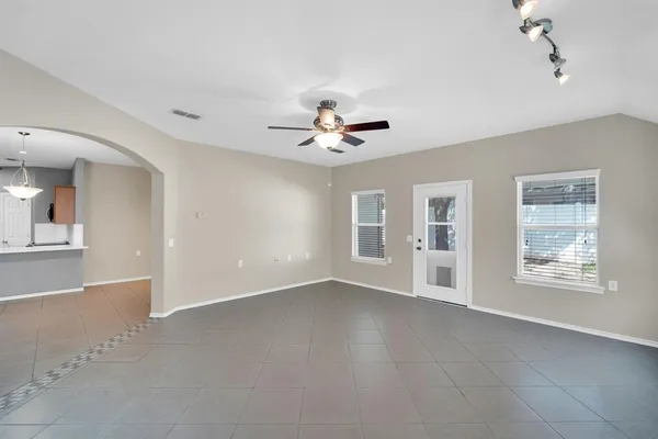 a view of an empty room with a window and a ceiling fan