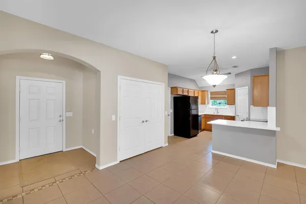 a view of a hallway with a chandelier fan and windows