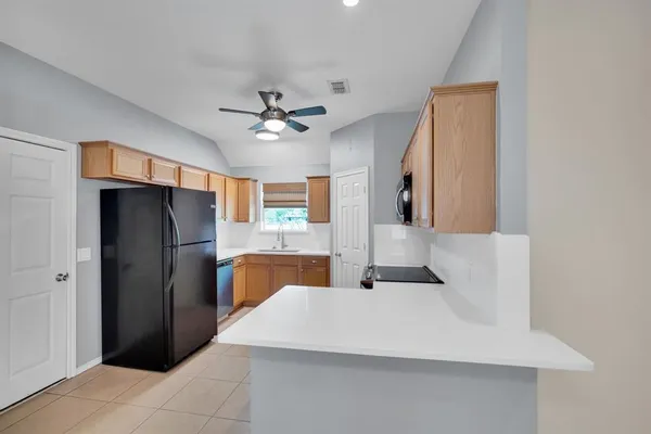 a view of a kitchen with refrigerator and windows
