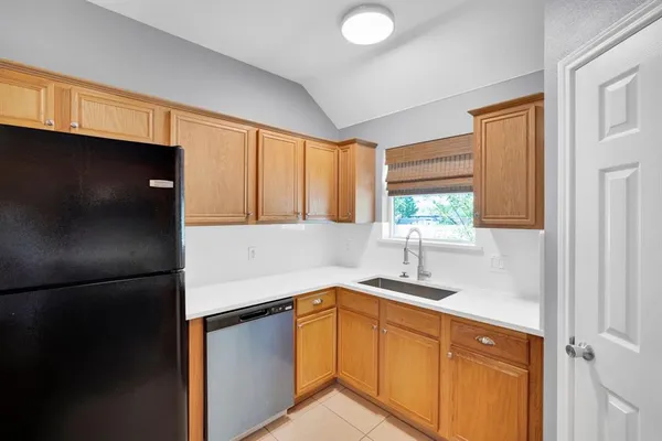 a large white kitchen with a large window and refrigerator