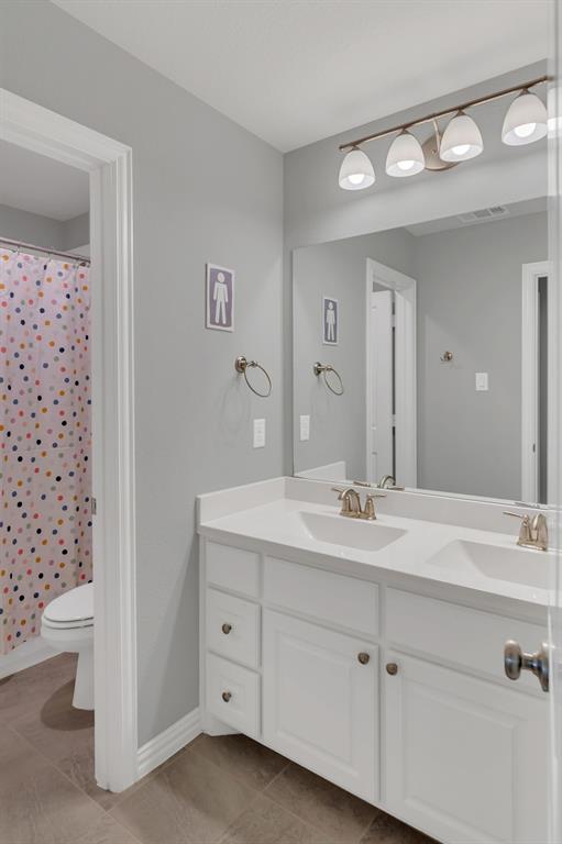 1920 Crescent Street Fort Worth, TX 76008 - Photo 28 of 40 a bathroom with a double vanity sink toilet and a mirror