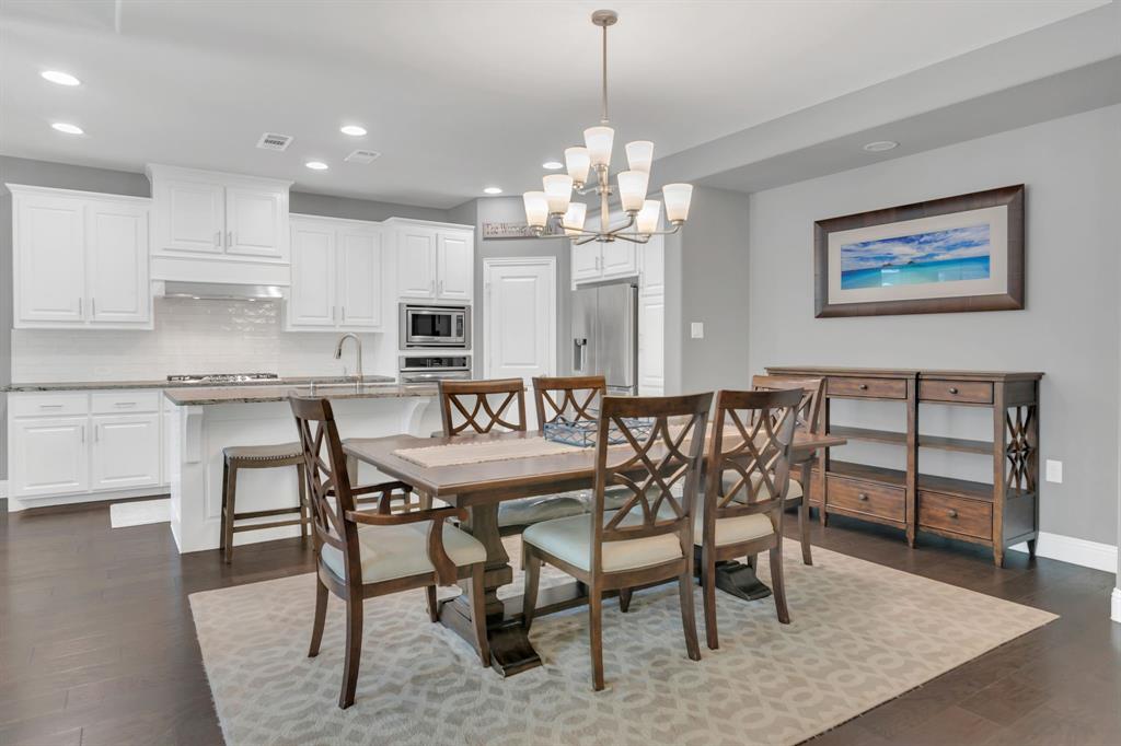 1920 Crescent Street Fort Worth, TX 76008 - Photo 7 of 40 a dining room with wooden floor a chandelier a wooden table and chairs