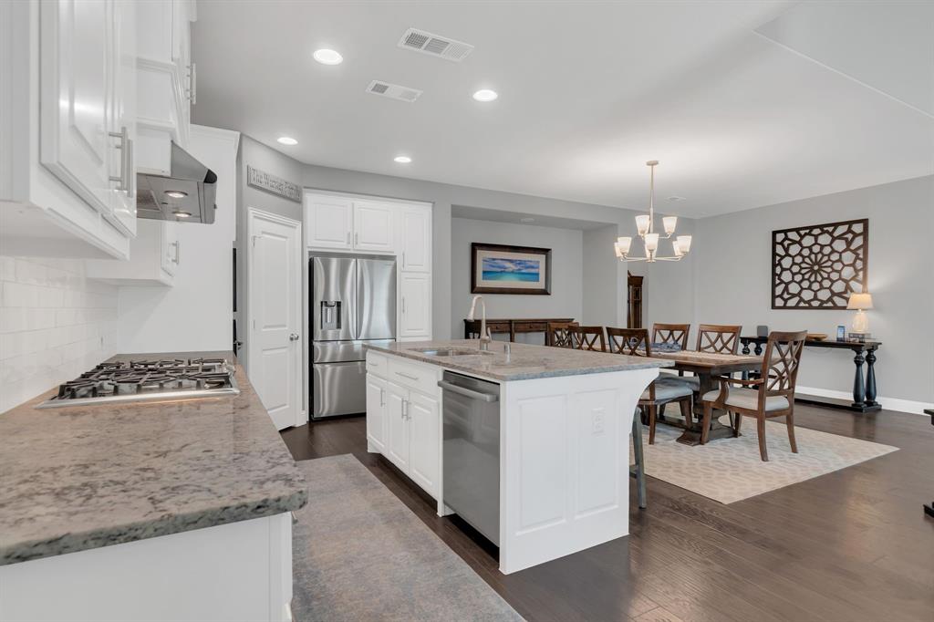 1920 Crescent Street Fort Worth, TX 76008 - Photo 10 of 40 a large kitchen with kitchen island a refrigerator a stove a dining table and chairs