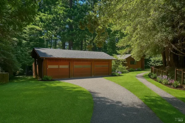 a front view of a house with a yard and trees