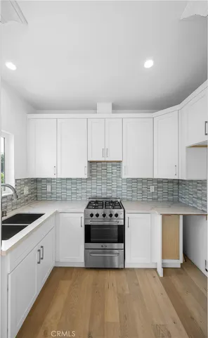 a kitchen with sink a stove and cabinets