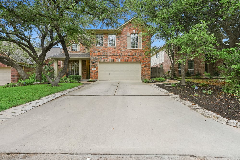 2823 Lantana Ridge Drive Austin, TX 78732 - Photo 1 of 34 a front view of a house with a yard and trees