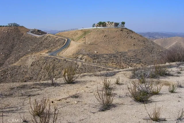 a view of a dry yard with mountains in the background