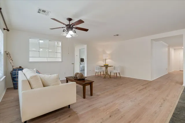 a living room with furniture and a ceiling fan