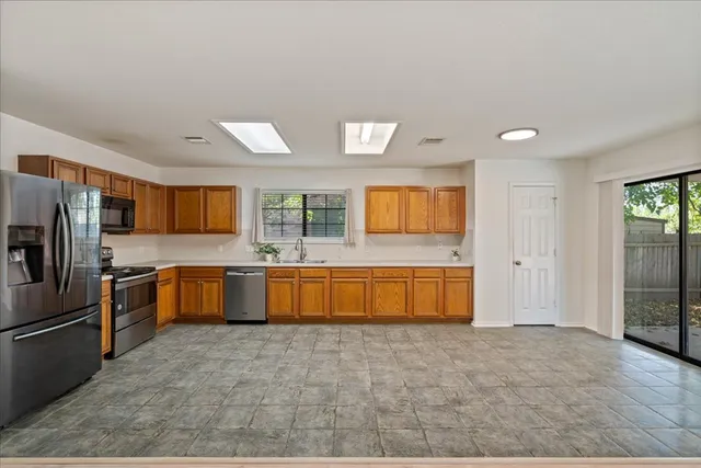 a large kitchen with a large window and refrigerator