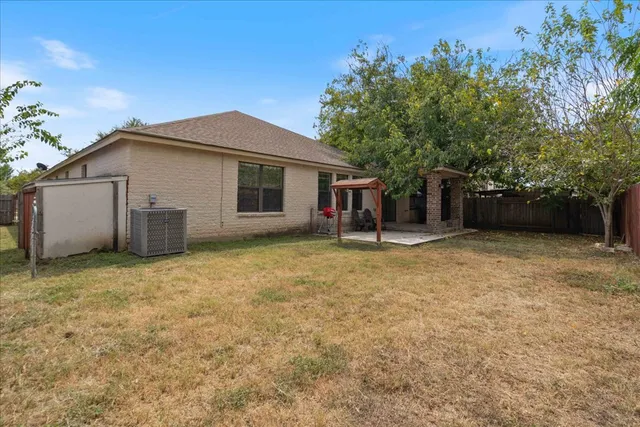 a front view of house with yard and trees in the background