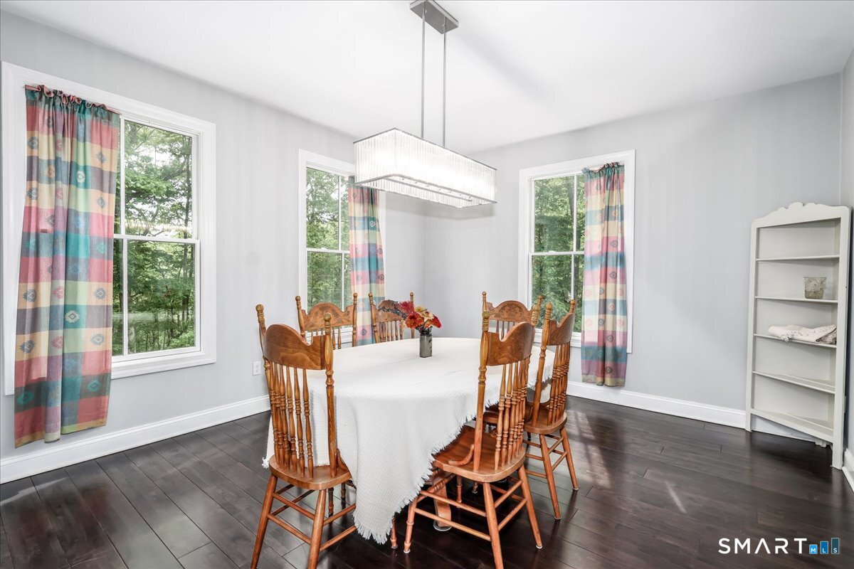 127 Putnam Park Road Bethel, CT 06801 - Photo 10 of 35 a dining room with furniture a chandelier and wooden floor