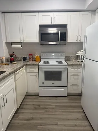 a kitchen with white cabinets stainless steel appliances and sink