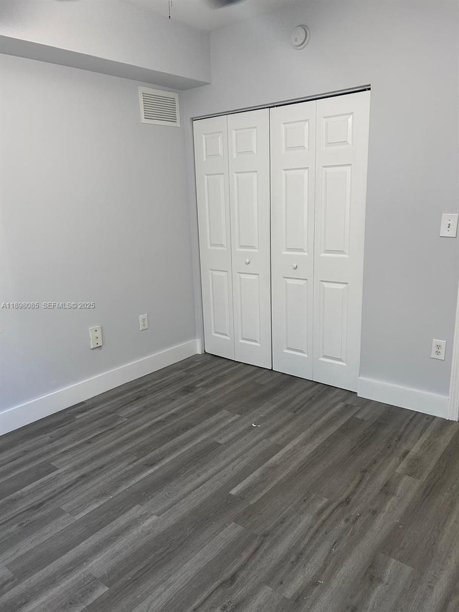 11060 Southwest 196th Street, Unit 103 Cutler Bay, FL 33157 - Photo 9 of 11 a view of an empty room with wooden floor