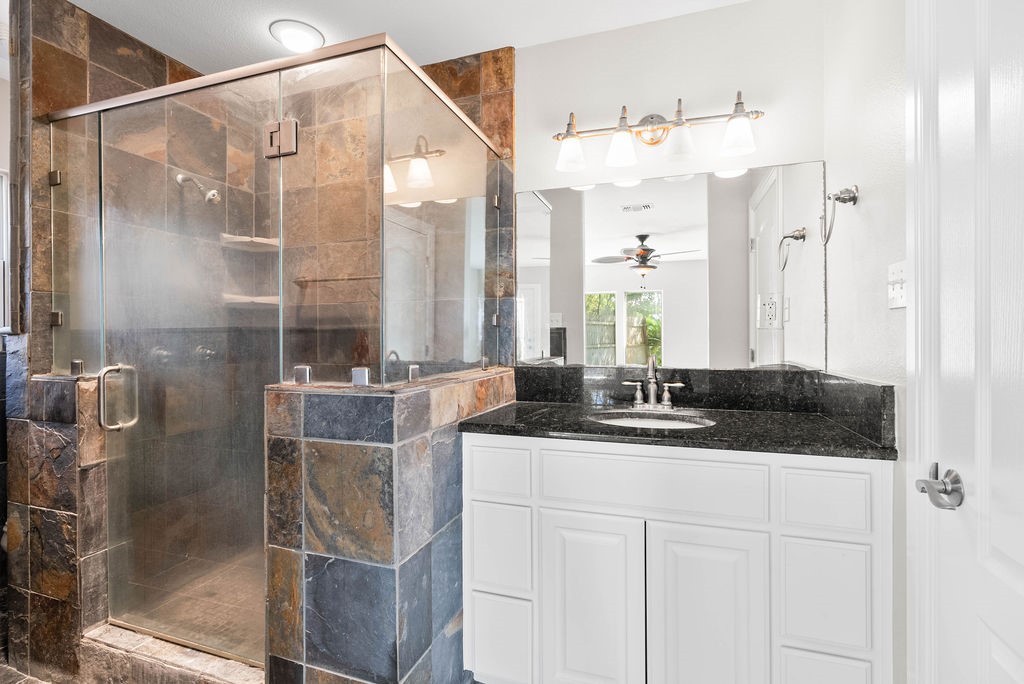 1931 North Fulton Beach Road Rockport, TX 78382 - Photo 30 of 40 a bathroom with a granite countertop sink a mirror and shower