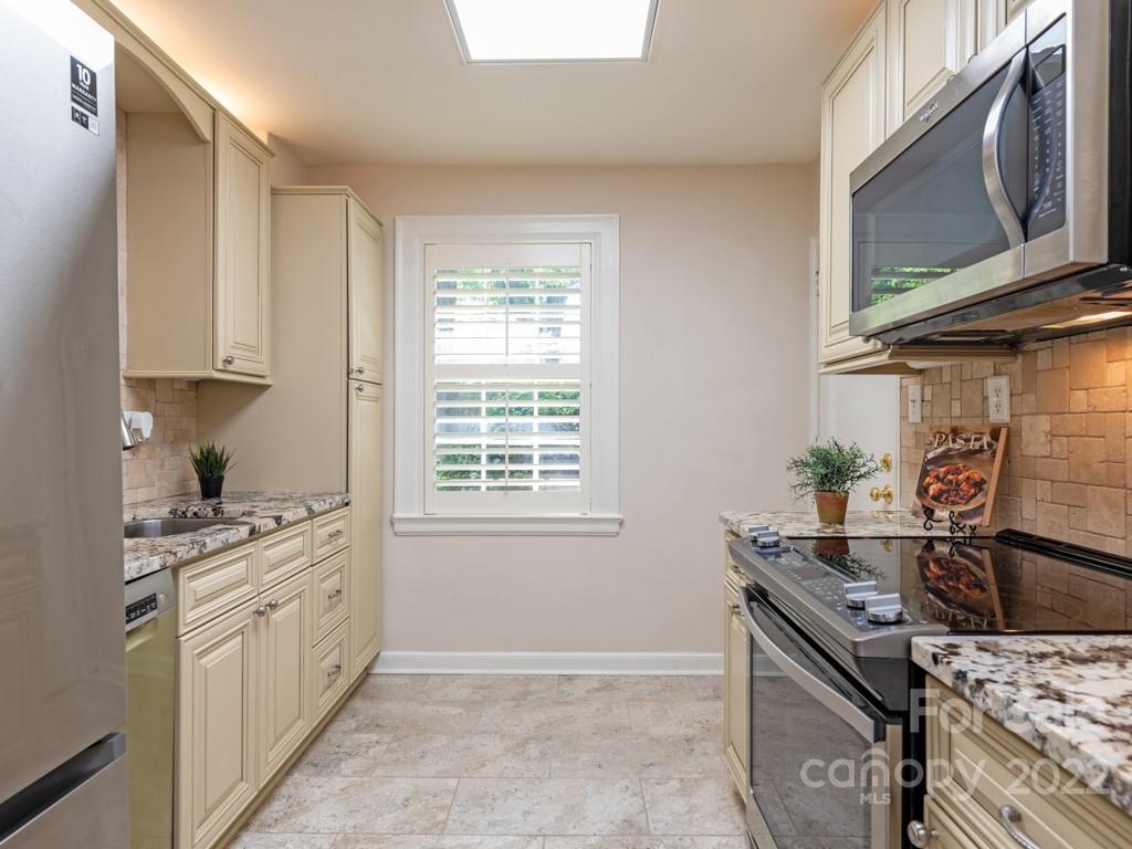 100 Colville Road, Unit 61A Charlotte, NC 28207 - Photo 6 of 15 a kitchen with a stove top oven sink and cabinets