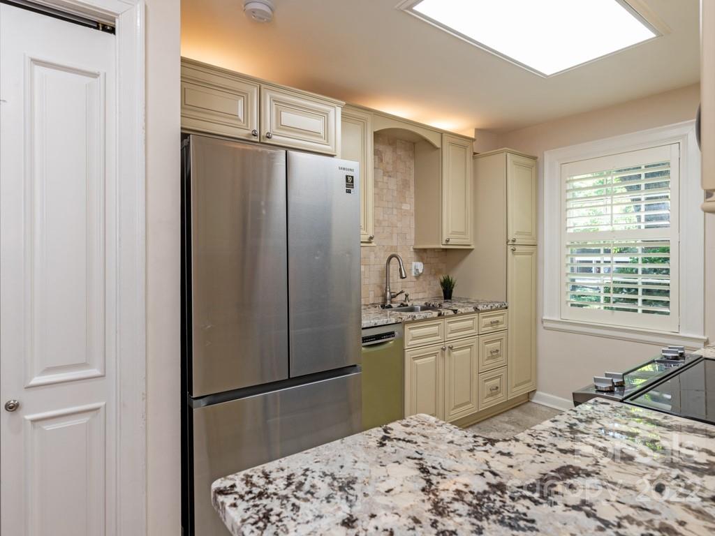 100 Colville Road, Unit 61A Charlotte, NC 28207 - Photo 7 of 15 a kitchen with stainless steel appliances granite countertop a refrigerator and a stove top oven