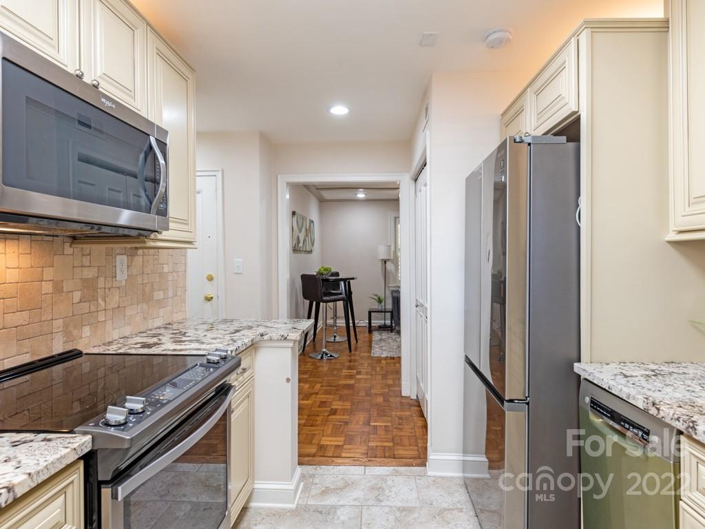 100 Colville Road, Unit 61A Charlotte, NC 28207 - Photo 8 of 15 a kitchen with granite countertop a stove and a refrigerator