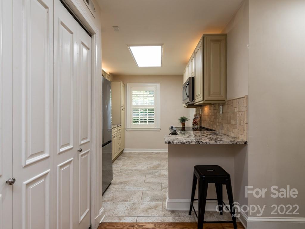100 Colville Road, Unit 61A Charlotte, NC 28207 - Photo 9 of 15 a kitchen with kitchen island granite countertop a refrigerator and a stove