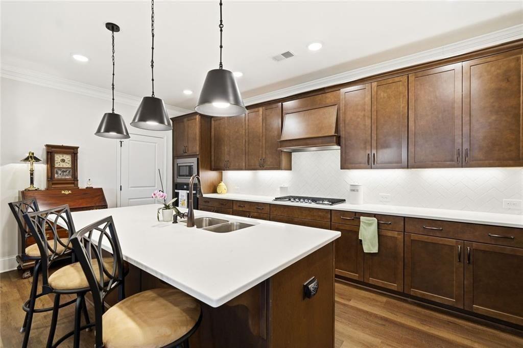 328 McQueen Way Canton, GA 30115 - Photo 22 of 66 a kitchen with a table chairs sink and cabinets
