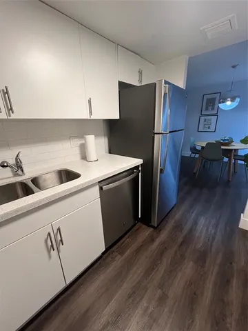 a kitchen with a refrigerator sink and cabinets