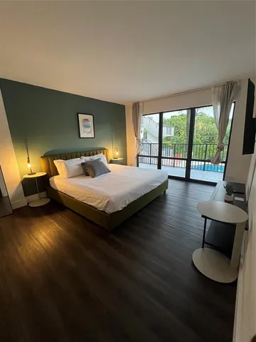 a bedroom with a bed and a couch next to a window