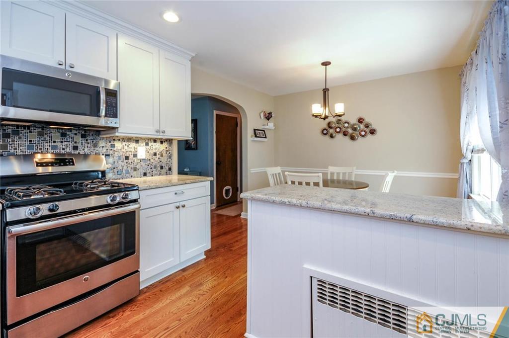 988 Clark Road North Brunswick, NJ 08902 - Photo 7 of 25 a kitchen with stainless steel appliances a stove a sink and a microwave