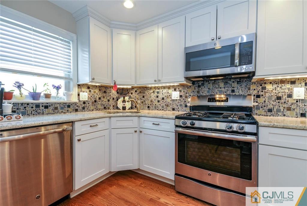 988 Clark Road North Brunswick, NJ 08902 - Photo 9 of 25 a kitchen with stainless steel appliances a stove a sink and a microwave
