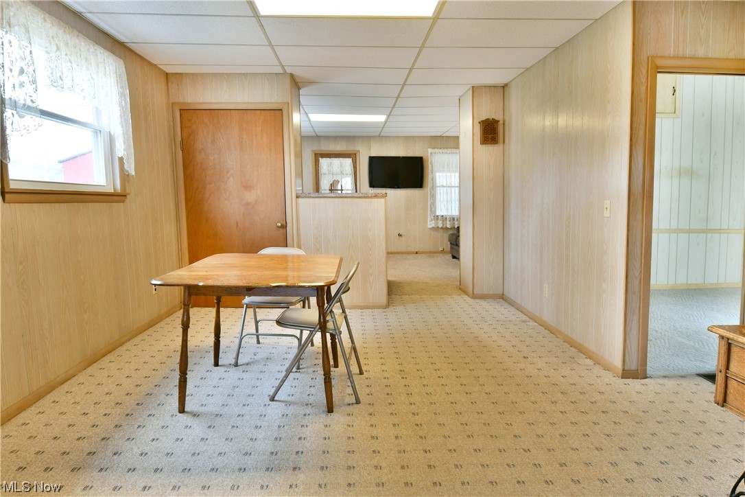2713 Ridge Road Cortland, OH 44410 - Photo 16 of 35 Dining space with wooden walls, light colored carpet, and a paneled ceiling
