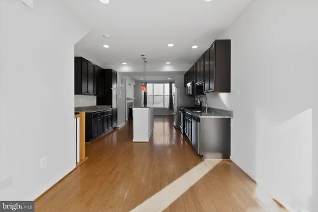 a kitchen with stainless steel appliances granite countertop a refrigerator stove top oven and sink