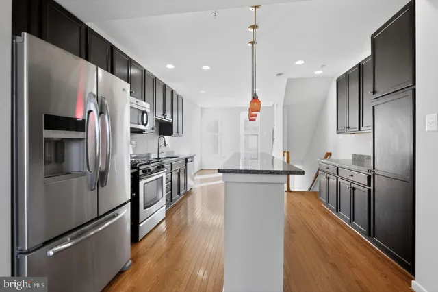 a kitchen with stainless steel appliances a refrigerator and a stove top oven