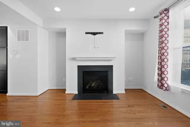 a living room with a fireplace and wooden floor