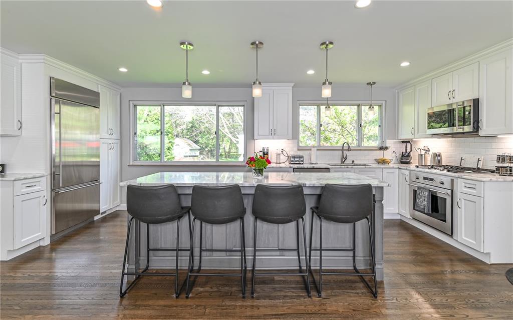 511 Chestnut Road Sewickley, PA 15143 - Photo 2 of 25 a kitchen with stainless steel appliances granite countertop a stove a refrigerator a sink with white cabinets and wooden floor