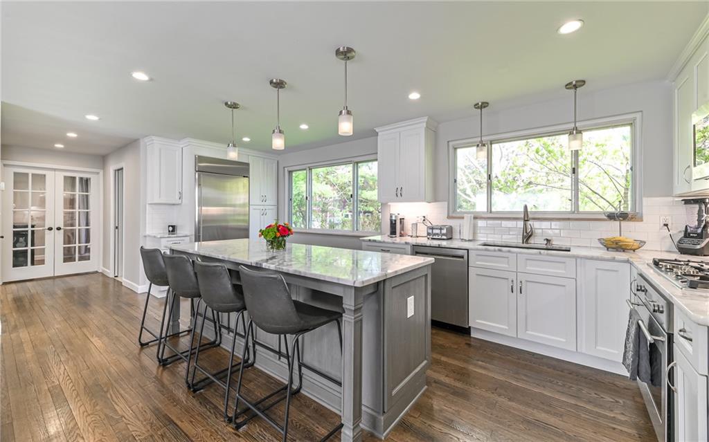 511 Chestnut Road Sewickley, PA 15143 - Photo 3 of 25 a kitchen with stainless steel appliances granite countertop wooden floors stove sink and cabinets