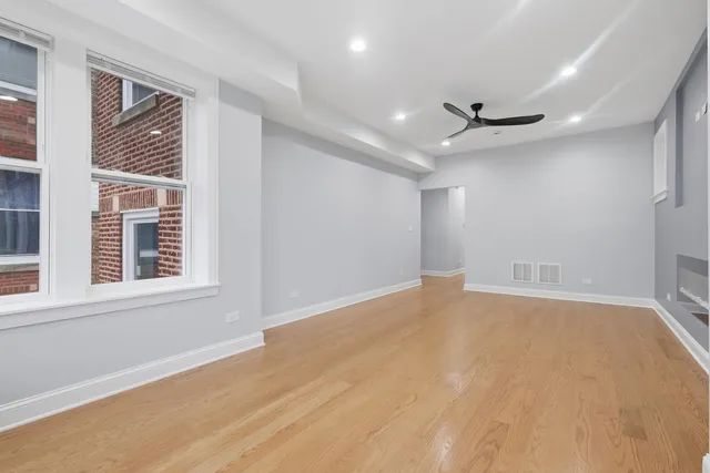 a view of an empty room with a window and a ceiling fan