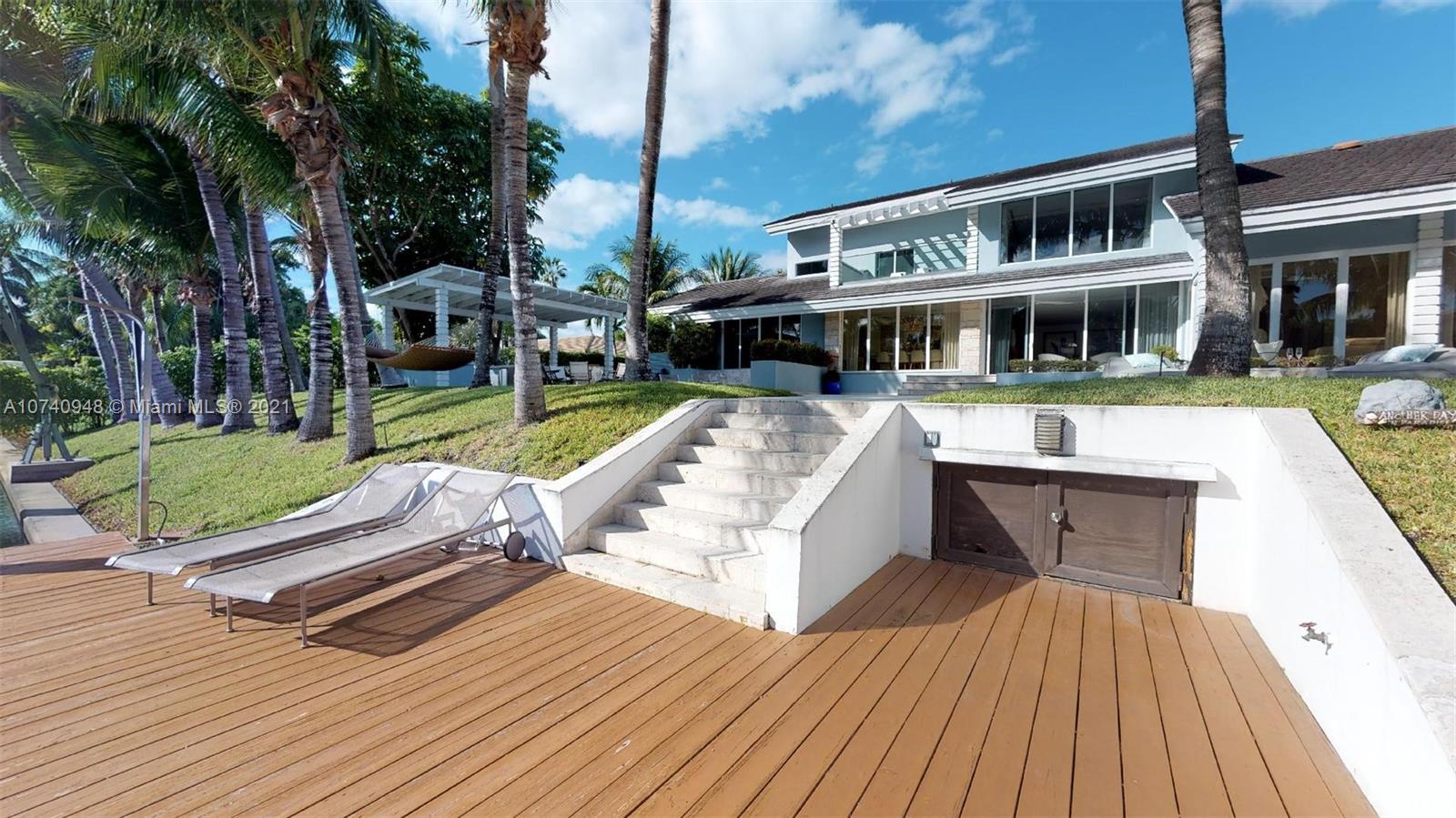 700 Lake Road Miami, FL 33137 - Photo 3 of 10 a view of a house with pool lawn chairs and wooden floor