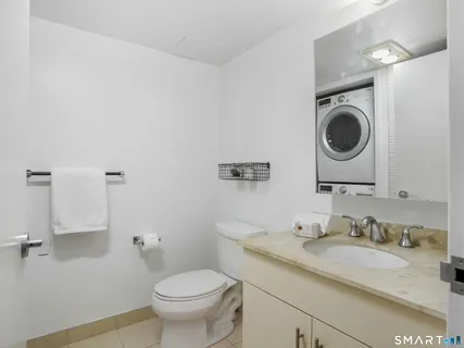 a bathroom with a granite countertop toilet sink and mirror