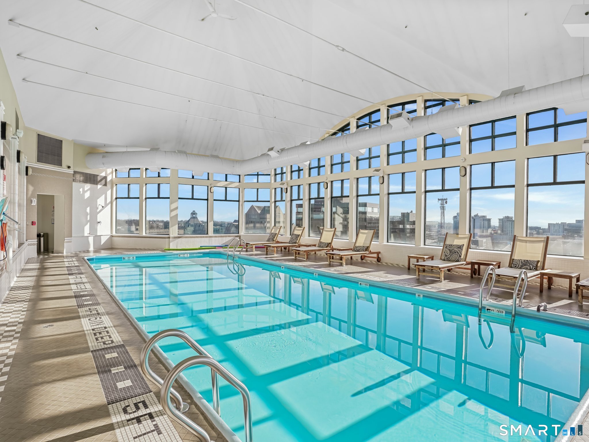 25 Forest Street, Unit 7D Stamford, CT 06901 - Photo 27 of 33 a room with lots of wooden cabinets a dining table and chairs
