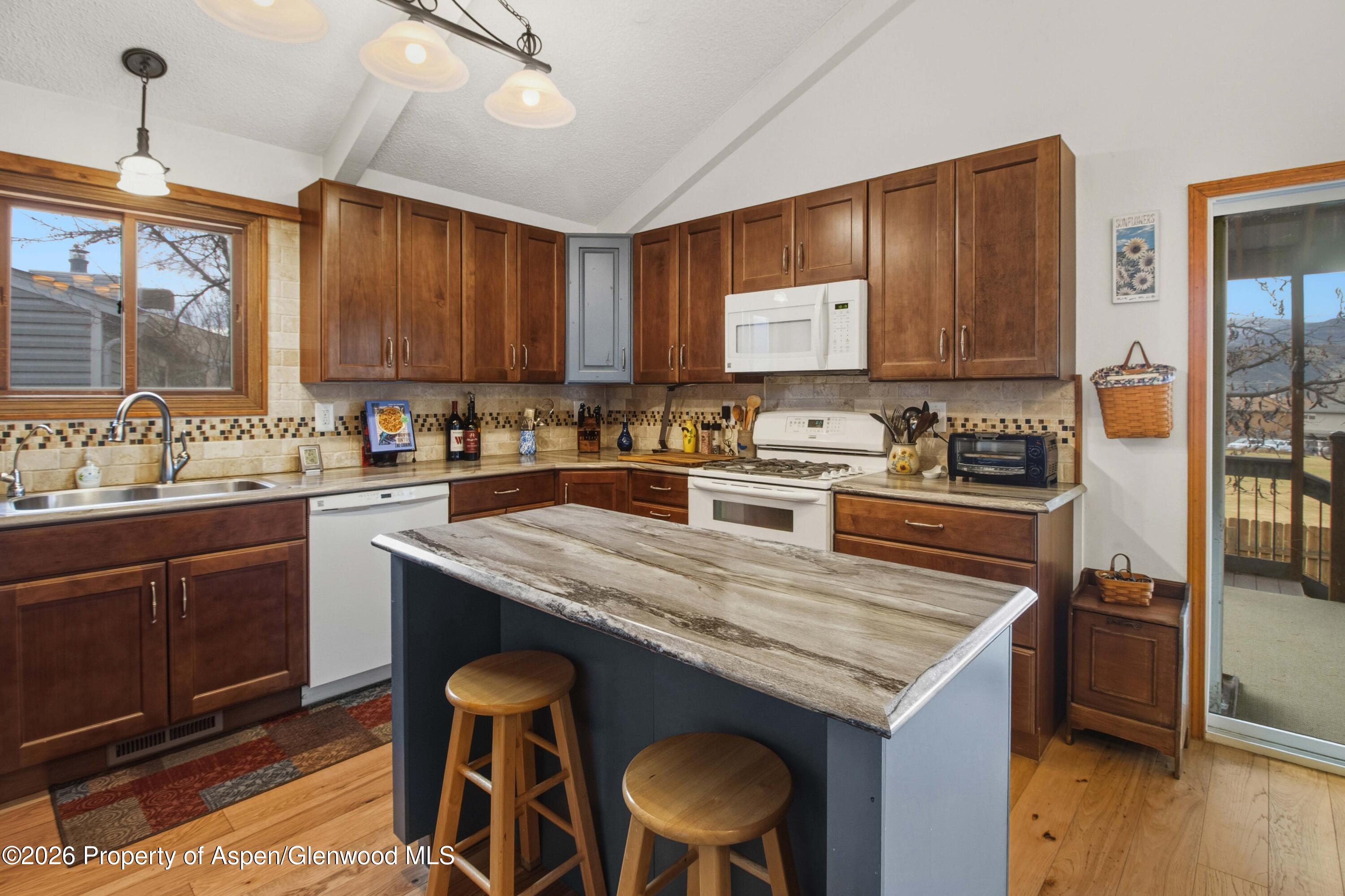 1441 Jays Avenue Rifle, CO 81650 - Photo 6 of 28 a kitchen with a stove a sink a microwave and wooden cabinets