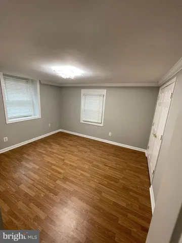 an empty room with wooden floor and window