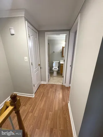 a view of a room with wooden floor and a bathroom