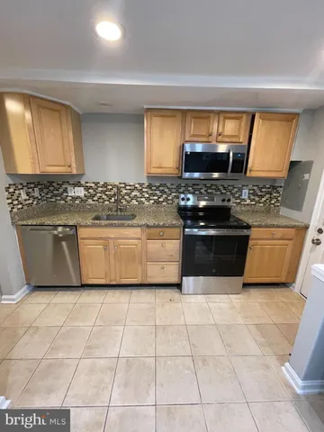 a kitchen with a stove top oven and cabinets