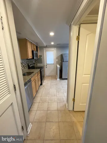 a large kitchen with a stove a refrigerator a sink a washer and dryer