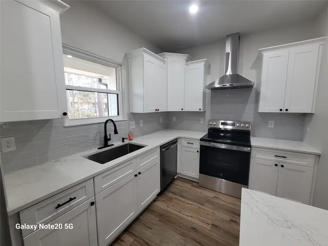 a kitchen with stainless steel appliances a sink stove and cabinets