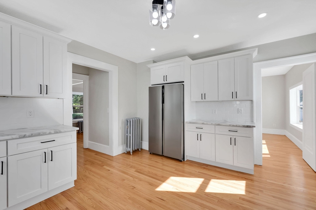 92 Grove Street West Springfield, MA 01089 - Photo 18 of 41 a kitchen with white cabinets and wooden floor