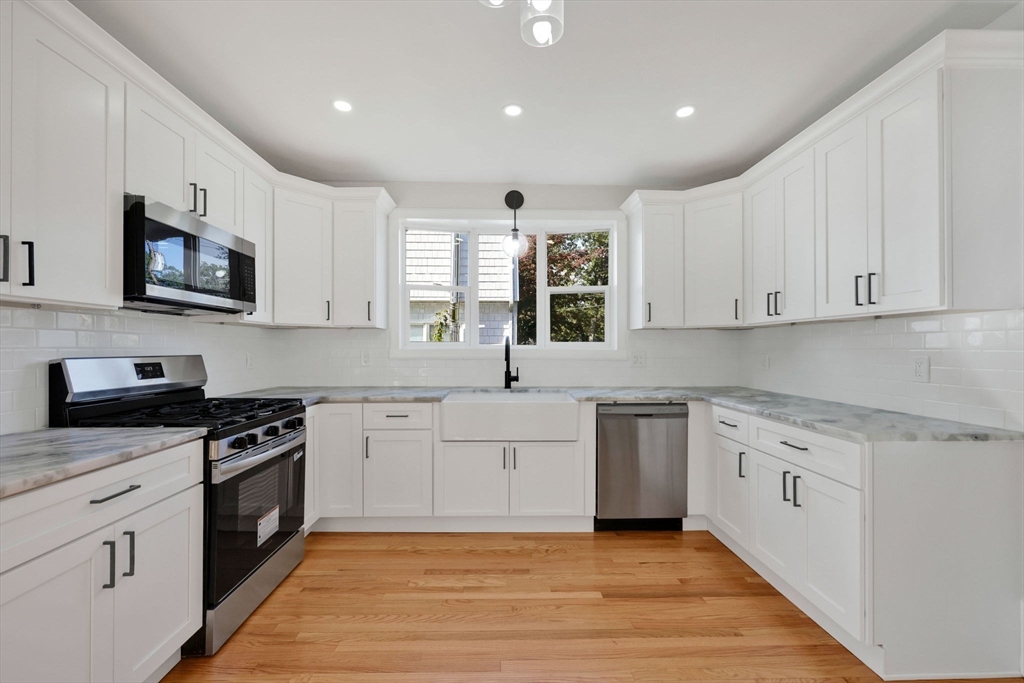 92 Grove Street West Springfield, MA 01089 - Photo 21 of 41 a large kitchen with stainless steel appliances granite countertop a stove a sink and a microwave