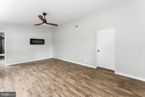 a view of empty room with wooden floor