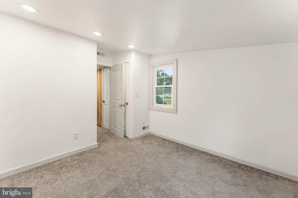 an empty room with windows and closet