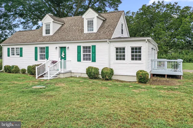 a view of a house with a yard and chairs
