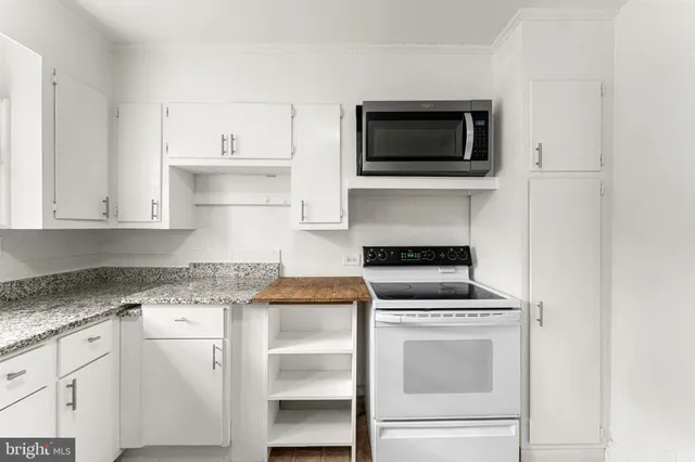 a kitchen with granite countertop white cabinets and white appliances